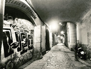 Illuminated street amidst buildings