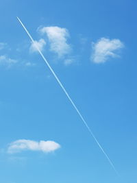 Low angle view of vapor trail in blue sky