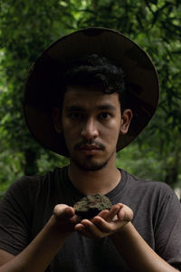 A geologist holds a mossy stone, defocused