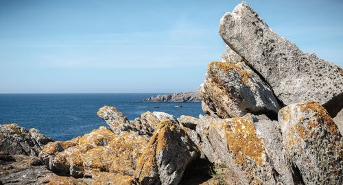 Rock formation on beach against sky