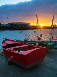 Boats moored on sea against sky during sunset
