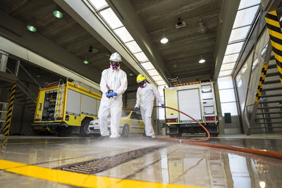 Two firefighters disinfecting the interior of a building