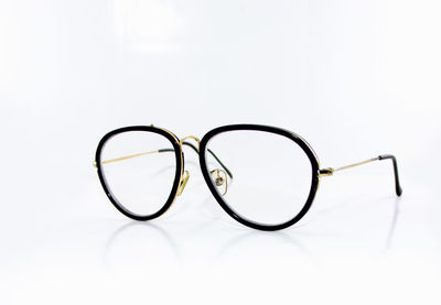 Close-up of eyeglasses on glass against white background