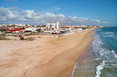 Panoramic view of beach and buildings against sky