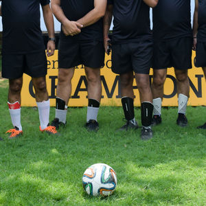 Low section of people standing on soccer field