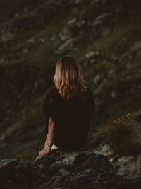 Rear view of woman standing on rock