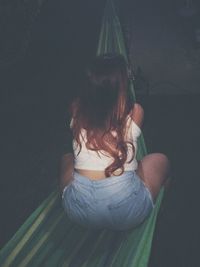 Rear view of woman sitting outdoors