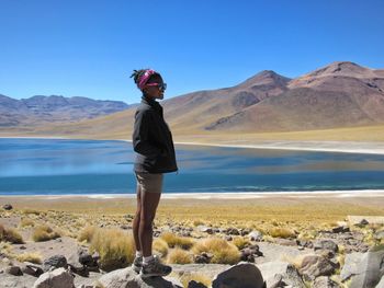 Full length of man standing on rock against sky