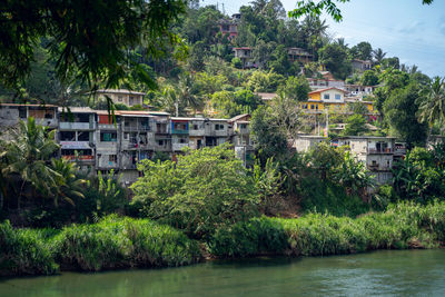 Buildings by river against sky