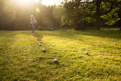 Senior woman playing with balls over grassy land in yard