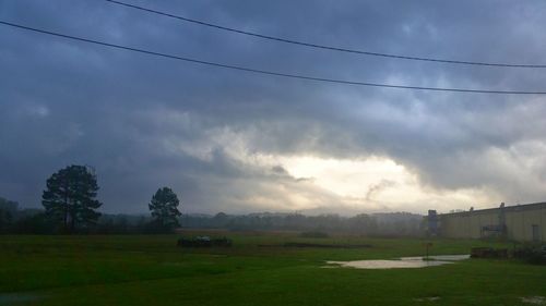 Scenic view of grassy field against cloudy sky