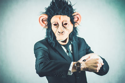 Man wearing monkey mask against white background