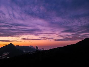 Silhouette mountains against dramatic sky during sunset