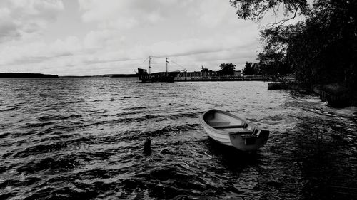 Boat moored in sea against sky