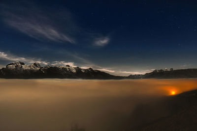 Scenic view of snowcapped mountains against sky at night