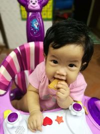 Close-up portrait of cute baby playing on bed at home