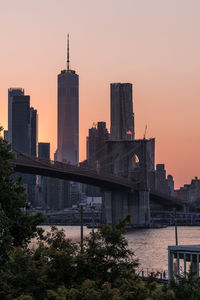 Modern buildings in city against sky during sunset