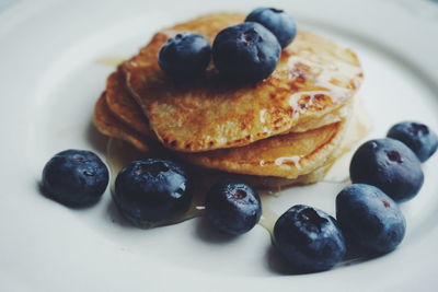 Blueberries and pancakes served in plate