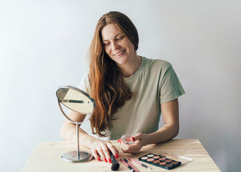 Portrait of smiling young woman sitting on table