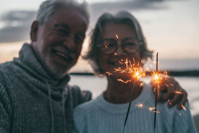 Portrait of woman holding sparkler at night