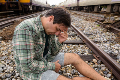 Side view of man preparing food on railroad tracks