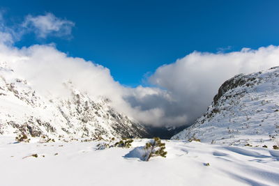 Scenic view of snow covered mountains against sky