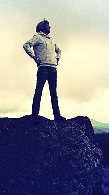 full length, lifestyles, standing, leisure activity, sky, casual clothing, men, rear view, low angle view, cloud - sky, rock - object, nature, young men, side view, tranquility, day, outdoors, tranquil scene