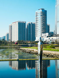 View of swimming pool by buildings against clear sky