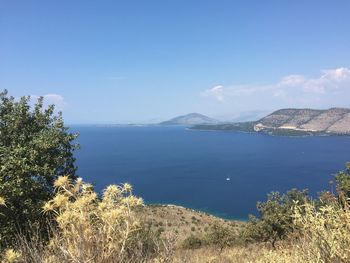 Scenic view of sea and mountains against blue sky