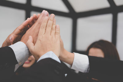 Cropped hand of business colleagues having high-five in office