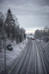 Railroad tracks against sky during winter