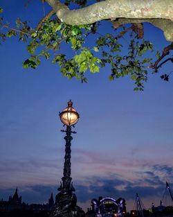 Low angle view of illuminated street light against sky