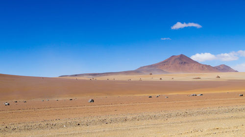 Scenic view of desert against clear blue sky