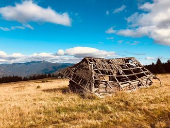 Abandoned barn on field against sky