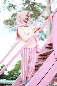 Low angle view of smiling woman standing on steps