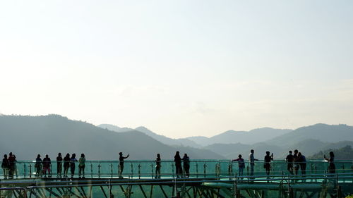 People at beach against clear sky