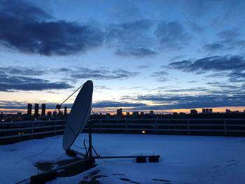 Scenic view of snow covered land against sky at sunset