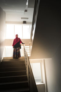 Low angle view of woman standing on staircase