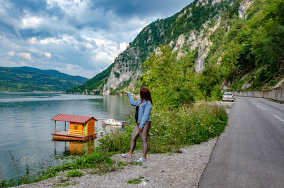 Rear view of woman walking on road against mountain