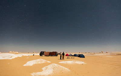 People on desert against sky