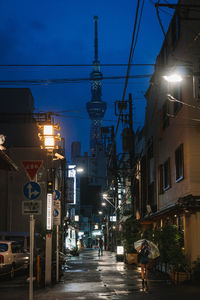 Illuminated street amidst buildings in city at night