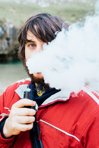 Portrait of young man holding snow