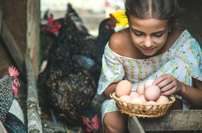 Cute girl holding eggs in basket