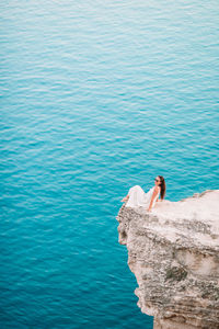 High angle view of man on rock by sea