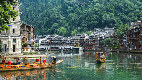 Boats in river with buildings in background