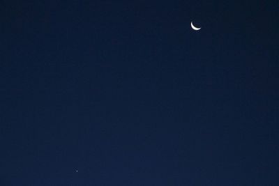 Low angle view of moon against blue sky