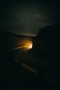 Illuminated road against sky at night