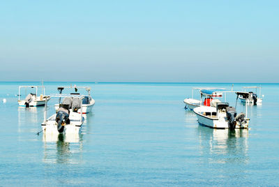 View of fishing boats in sea against clear sky