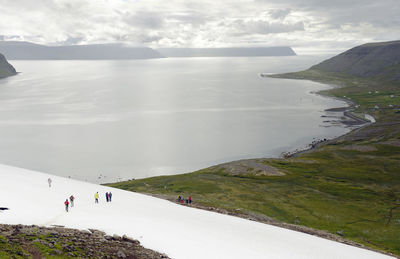 Scenic view of mountain and snow against sky and fjord