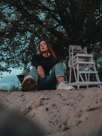 Portrait of young woman sitting on land